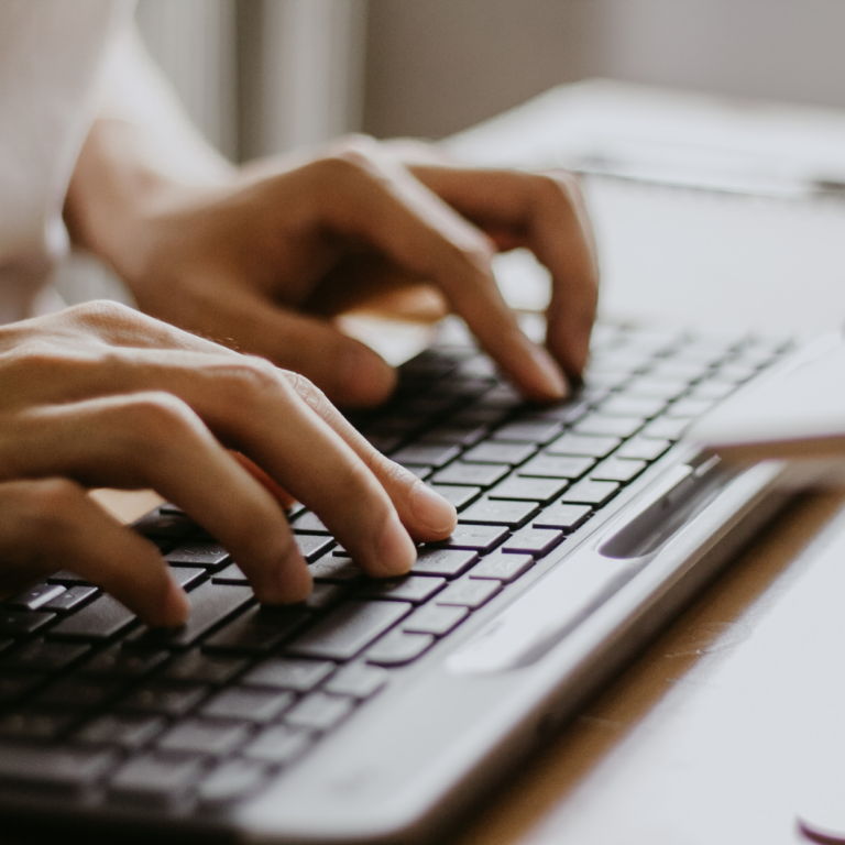 Zwei Hände über der Tastatur die eine Bibliothekssoftware bedienen.